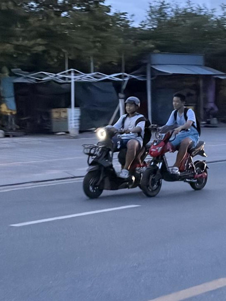 越南胡志明市富美坊街头，市民驾驶电摩出行 图源：新华社